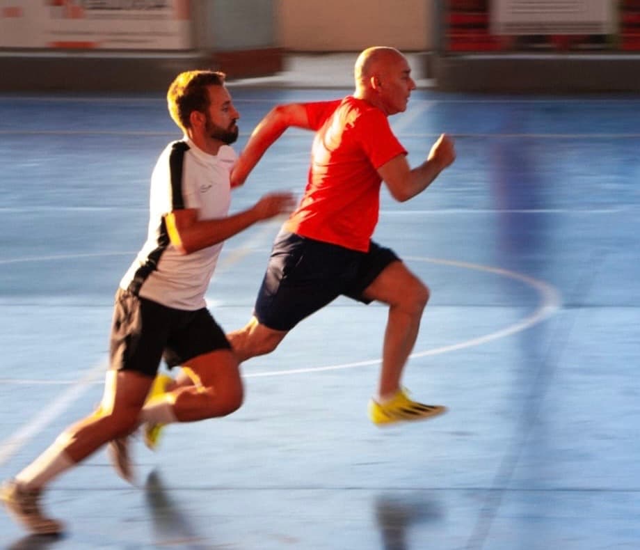 Dos jugadores corriendo en una pista cubierta
